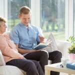 Home Care San Diego Caregiver Reading Book to Senior Alzheimers